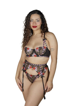 Close-up of the Blush Noir lingerie showcasing its delicate pink and red floral embroidery on black fabric.